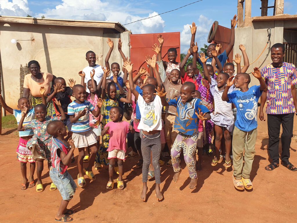 Clément, Atsou et leur mère avec les jeunes résidents devant le centre Wisdom House.